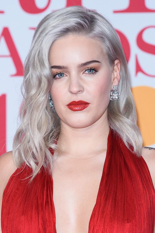 Anne-Marie Wavy Silver Dark Roots, Uneven Color Hairstyle | Steal Her Style