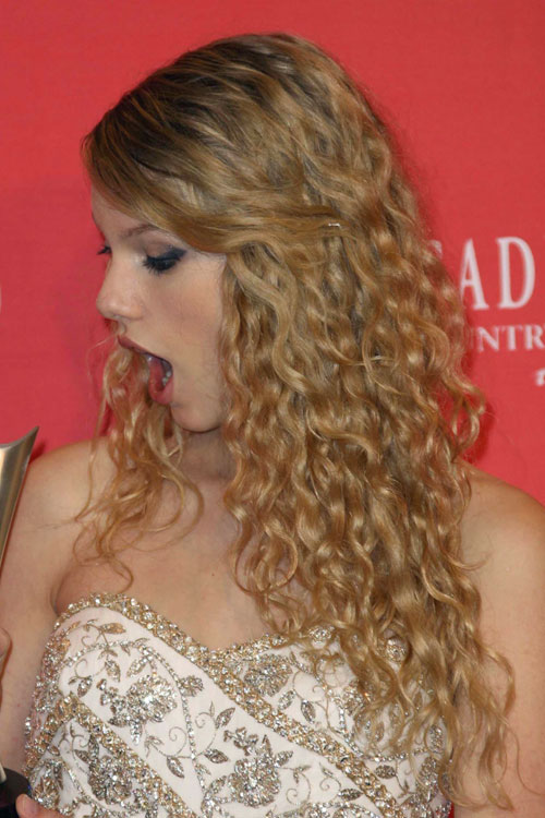 Taylor Swift Curly Honey Blonde Angled Pinned Back Hairstyle