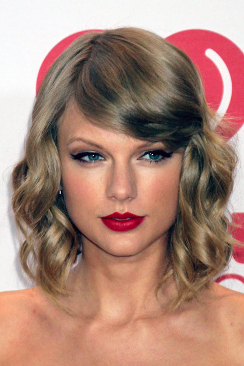Taylor Swift Wavy Ash Blonde Sideswept Bangs Hairstyle 